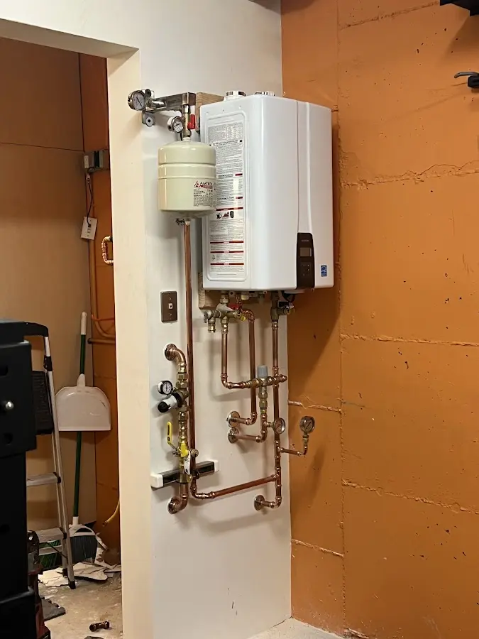 Plumbing technician inspecting water heater connections in Cornwall